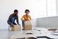 Satisfied smiling millennial african american husband and wife stack cardboard boxes, packing stuff and prepare to move Royalty Free Stock Photo