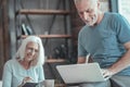 Satisfied unshaken man sitting and working with the laptop. Royalty Free Stock Photo