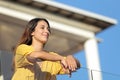 Satisfied woman contemplating views in a balcony