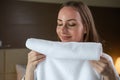 Satisfied woman enjoys smelling clean and fresh terry towel