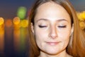 Satisfied woman in front of urban night sky