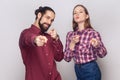 Satisfied woman and man standing pointing at camera, selecting you, expressing positive emotions. Royalty Free Stock Photo