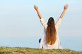 Satisfied woman raising arms watching sky