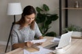 Satisfied woman reading good news in letter, sitting at desk Royalty Free Stock Photo