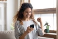 Satisfied woman reading good news, looking at phone screen