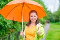 Satisfied woman with umbrella on the walk