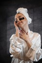 Satisfied woman in white towel applying eye patches for puffiness, wrinkles Royalty Free Stock Photo