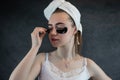 Satisfied woman in white towel applying eye patches for puffiness, wrinkles Royalty Free Stock Photo