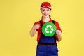 Satisfied worker woman standing and holding recycling sign, thinking green, pointing at camera.