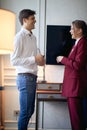 Satisfied young business couple smiling, standing in hotel room, looking each other Royalty Free Stock Photo