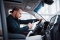 Satisfied young business man looking at mobile phone while driving a car Royalty Free Stock Photo