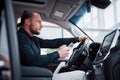 Satisfied young business man looking at mobile phone while driving a car Royalty Free Stock Photo