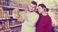 Satisfied young couple choosing purchasing canned food for week Royalty Free Stock Photo