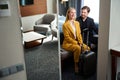 Satisfied young couple sitting on bench in hotel room Royalty Free Stock Photo