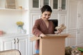 Satisfied young indian woman unpack box with groceries ordered online