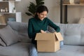 Satisfied young latin woman open postal delivery with consumer goods