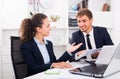 Satisfied young man and woman coworkers talking in firm office Royalty Free Stock Photo