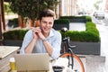 Satisfied young stylish man in shirt working on laptop Royalty Free Stock Photo
