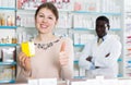 Satisfied woman with medicines showing thumb up