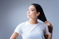 Satisfied young woman touching her hair after using new shampoo