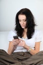 Satisfied young woman uses her cell phone for text messaging