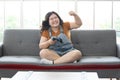 Satisfy chubby woman play video games at home and raised hand for joyful or mission complete