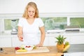 Satisfying her appetite with healthy alternatives. Curvaceous young woman eating fruit in her kitchen.