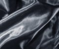 Saturated Black brilliant silk background with folds