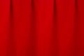 Saturated scarlet red silk curtain with smooth creases as luxury classic theatre abstract background. Royalty Free Stock Photo
