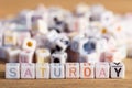 Saturday written in letter beads on wood background