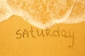 Saturday - written in sand on beach texture Royalty Free Stock Photo