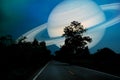 Saturn near earth on night sky over the country road