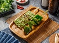 SauceFour Seasons spicy grilled Green Pepper sticks in wooden dish isolated mate and grey background top view