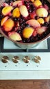 A saucepan with berry compote boils on the stove, berry compote