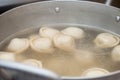 Saucepan with dumplings in hot water coming to a boil a second before filling the stomach semi-finished