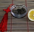 Saucer with leaves of tea and the cut lemon on a rug Royalty Free Stock Photo