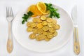 Money coins on white plate with fork and knife, is