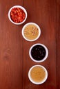 Sauces ketchup, mustard, mayonnaise, sour cream, soy sauce in clay bowls on wooden background. Top view