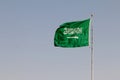 Saudi Arabian Flag waving against a blue background