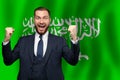 Saudi Arabian happy businessman on the background of flag of Saudi Arabia Business, education, degree and citizenship concept