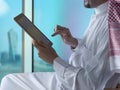 Saudi Arabian Man Using Tablet Beside Window