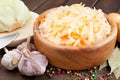 Sauerkraut with carrot in wooden bowl, garlic, spices