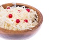 Sauerkraut with cranberries in wooden bowl on white background