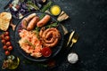 Sauerkraut and grilled sausages with rosemary and cranberries on a black plate. Traditional German dish. Royalty Free Stock Photo