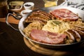 Sauerkraut pan with small fried Bavarian German NÃÂ¼rnberger sausages, smoked Kassler pork neck, mashed potatoes, mustard and spice Royalty Free Stock Photo