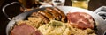 Sauerkraut pan with small fried Bavarian German NÃÂ¼rnberger sausages, smoked Kassler pork neck, mashed potatoes, mustard and spice Royalty Free Stock Photo