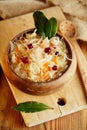 Sauerkraut - Sour cabbage - on wooden bowl with bay leaves