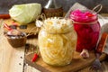 Sauerkraut variety preserving jars. Homemade Sauerkraut with Carrot and Salad Cabbage with Beetroot on a wooden table.