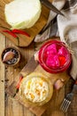 Sauerkraut variety preserving jars. Homemade Sauerkraut with Carrot and Salad Cabbage with Beetroot on a wooden table.