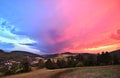 Sauerland, Germany - Rear view of a disappearing thunderstorm at sunset with dramatic blue and pink cloudscape over wooded hills Royalty Free Stock Photo